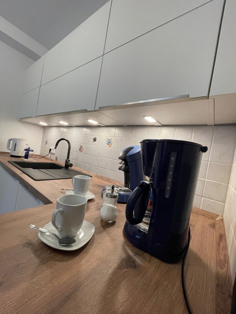 Ansicht Küche, im Vordergrund Kaffeemaschine mit Kaffeetasse
